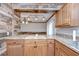 Lovely kitchen with granite countertops, wood cabinets, and a view of the dining and living areas at 40019 Pretty Redbird Rd, Zephyrhills, FL 33540