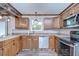 Charming kitchen showcasing wood cabinets, stainless steel appliances, and a bright, airy atmosphere at 40019 Pretty Redbird Rd, Zephyrhills, FL 33540