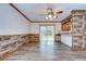 Bright living room featuring wood-look floors, rustic wood trim, and sliding glass doors to the yard at 40019 Pretty Redbird Rd, Zephyrhills, FL 33540