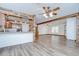 Inviting living room with wood-look floors, exposed beams, and open-concept design to the kitchen at 40019 Pretty Redbird Rd, Zephyrhills, FL 33540