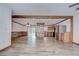 Spacious living room featuring wood-look flooring, wood-clad walls, and an open layout to the kitchen at 40019 Pretty Redbird Rd, Zephyrhills, FL 33540
