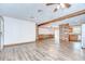 Spacious open-concept living area with wood-look flooring and wood beam accent at 40019 Pretty Redbird Rd, Zephyrhills, FL 33540