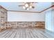Cozy living room with wood-look flooring, wood-clad walls, and sliding door to the exterior at 40019 Pretty Redbird Rd, Zephyrhills, FL 33540