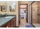 Bathroom featuring dual sinks, granite countertops, custom cabinets, walk-in shower, and a vanity at 4400 English Turn Way, Wesley Chapel, FL 33543