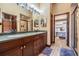 The bathroom features dual sinks, granite countertops, custom cabinets, and an adjacent vanity at 4400 English Turn Way, Wesley Chapel, FL 33543