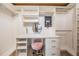 Custom walk-in closet/dressing room with vanity, plush stool, and secure safe at 4400 English Turn Way, Wesley Chapel, FL 33543