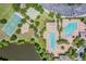 Overhead view of a large community pool area with multiple pools, lounge chairs, and lush landscaping at 4400 English Turn Way, Wesley Chapel, FL 33543