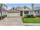 Inviting home with a beautiful paver driveway, lush landscaping, and a charming facade, perfect for comfortable suburban living at 4400 English Turn Way, Wesley Chapel, FL 33543