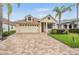 Attractive home with a paver driveway, well-maintained lawn, and tropical palm trees, creating an inviting curb appeal in a sunny locale at 4400 English Turn Way, Wesley Chapel, FL 33543