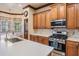 A well-appointed kitchen offers an island sink, stone countertops, wood cabinets, and stainless appliances at 4400 English Turn Way, Wesley Chapel, FL 33543