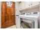 Well-equipped laundry room with front load washer and dryer and overhead cabinets at 4400 English Turn Way, Wesley Chapel, FL 33543