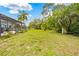 Expansive backyard featuring lush greenery and a screened-in lanai, perfect for outdoor enjoyment at 4419 Gaston St, Spring Hill, FL 34607