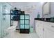 Bright bathroom featuring a glass shower, storage shelves, and a sleek vanity at 4419 Gaston St, Spring Hill, FL 34607