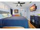 Cozy bedroom featuring hardwood floors, ceiling fan, and wall-mounted television at 4419 Gaston St, Spring Hill, FL 34607