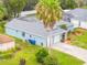 Charming blue home featuring a two-car garage and well-maintained landscaping at 4419 Gaston St, Spring Hill, FL 34607