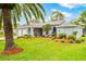 Charming single-story home with a well-manicured lawn, lush landscaping, and a three-car garage, exuding curb appeal at 4419 Gaston St, Spring Hill, FL 34607