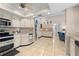 Bright and spacious kitchen with white cabinetry, tile floors, and seamless flow to living area at 4419 Gaston St, Spring Hill, FL 34607