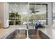 Kitchen sink area with a view of the screened-in pool and lush landscaping through a large window at 4419 Gaston St, Spring Hill, FL 34607