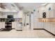Well-designed kitchen with stainless appliances, white cabinets, tile flooring and adjacent living spaces at 4419 Gaston St, Spring Hill, FL 34607