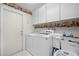 Functional laundry room featuring storage cabinets, washer, dryer and decorated with decorative border at 4419 Gaston St, Spring Hill, FL 34607