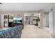 Open-concept living room featuring tile floors, a comfortable couch, a large television, and a view into the kitchen at 4419 Gaston St, Spring Hill, FL 34607