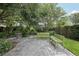 An inviting backyard with lush trees, green benches, and a stone fountain at 4926 Pennecott Way, Wesley Chapel, FL 33544