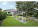 Landscaped backyard with a stone patio, lush green grass, and cozy seating, perfect for outdoor enjoyment at 4926 Pennecott Way, Wesley Chapel, FL 33544
