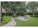 Serene backyard with a stone patio, green benches, and lush greenery at 4926 Pennecott Way, Wesley Chapel, FL 33544