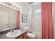 Well-lit bathroom with shower/tub combo, single sink vanity, mirror, and framed art over the toilet at 4926 Pennecott Way, Wesley Chapel, FL 33544