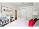 Bright bedroom features large closet, a picture on the wall and bookcase next to a comfortable bed with red pillows at 4926 Pennecott Way, Wesley Chapel, FL 33544