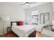Bright bedroom with hardwood floors, a comfortable bed, a window with view, and a stylish mirror on the wall at 4926 Pennecott Way, Wesley Chapel, FL 33544