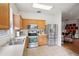 Functional kitchen with stainless steel appliances, light wood cabinets, and tile flooring at 4926 Pennecott Way, Wesley Chapel, FL 33544