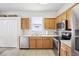 Efficient kitchen features stainless steel appliances, wood cabinets, and a bright window at 4926 Pennecott Way, Wesley Chapel, FL 33544