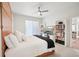 Bright bedroom featuring a ceiling fan, work space, bookshelves and large windows at 4926 Pennecott Way, Wesley Chapel, FL 33544
