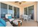 Inviting balcony features comfortable seating, ceiling fan, and partial views of living area and ocean at 4953 Bacopa S Ln # 205, St Petersburg, FL 33715