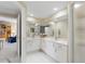 Bright bathroom featuring double sinks, white cabinetry, and large mirrors for a spa-like experience at 4953 Bacopa S Ln # 205, St Petersburg, FL 33715