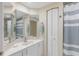 Well-lit bathroom featuring a single sink vanity, large mirror, and a shower with a striped curtain at 4953 Bacopa S Ln # 205, St Petersburg, FL 33715