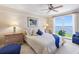 Comfortable bedroom featuring large window with water view, ceiling fan, and tasteful furnishings at 4953 Bacopa S Ln # 205, St Petersburg, FL 33715