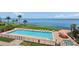 Community pool with ocean view, lounge chairs, and adjacent spa at 4953 Bacopa S Ln # 205, St Petersburg, FL 33715
