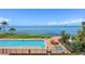 Resort-style pool area with lounge chairs, umbrellas, spa, and beautiful water views at 4953 Bacopa S Ln # 205, St Petersburg, FL 33715