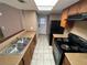 Bright kitchen area featuring black range and refrigerator, light countertop, and wooden cabinetry at 5042 Terrace Village Ln, Tampa, FL 33617