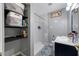 Bathroom with a white subway tile shower, shelves, and a blue vanity at 538 Bamboo Ln, Clearwater, FL 33764