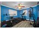 Bright home gym with blue walls, ceiling fan, and exercise equipment at 538 Bamboo Ln, Clearwater, FL 33764