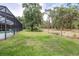 View of screened enclosure and backyard that overlooks a grassy lawn at 5931 Cherry Oak Dr, Valrico, FL 33596