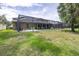 An exterior view of the home's pool and screen enclosed patio from the green, grassy backyard at 5931 Cherry Oak Dr, Valrico, FL 33596