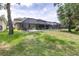 The fenced yard offers a view of the back of the house and screened-in pool area at 5931 Cherry Oak Dr, Valrico, FL 33596
