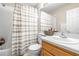 Well-lit bathroom features a single vanity, updated fixtures, and a shower-tub combo with a shower curtain at 5931 Cherry Oak Dr, Valrico, FL 33596