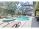 Enclosed pool area boasts a sparkling pool, in-ground hot tub, lounge chairs, and serene backyard views at 5931 Cherry Oak Dr, Valrico, FL 33596