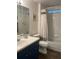 Bright bathroom with a shower over the tub, wood look floors, and vanity with white countertop at 6905 Summer Harbor Ln, Riverview, FL 33578