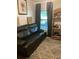 Comfortable living room featuring a recliner couch, shelving unit, and large window overlooking outdoor space at 6905 Summer Harbor Ln, Riverview, FL 33578